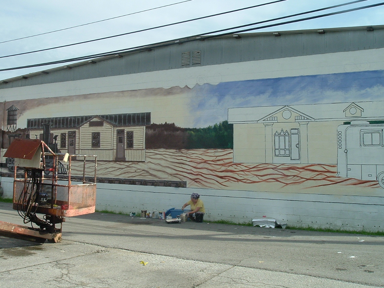 Red Bay mural and artist at work